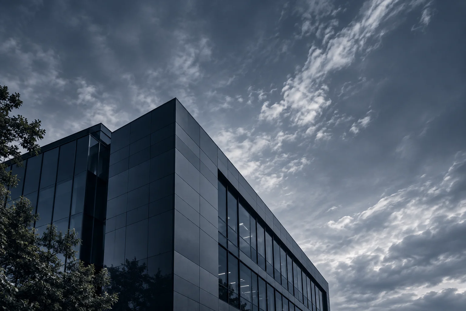 Dark glass building beneath an overcast sky